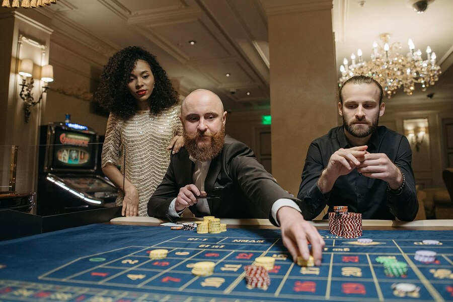 Goście przy stole pokerowym w nastrojowym świetle