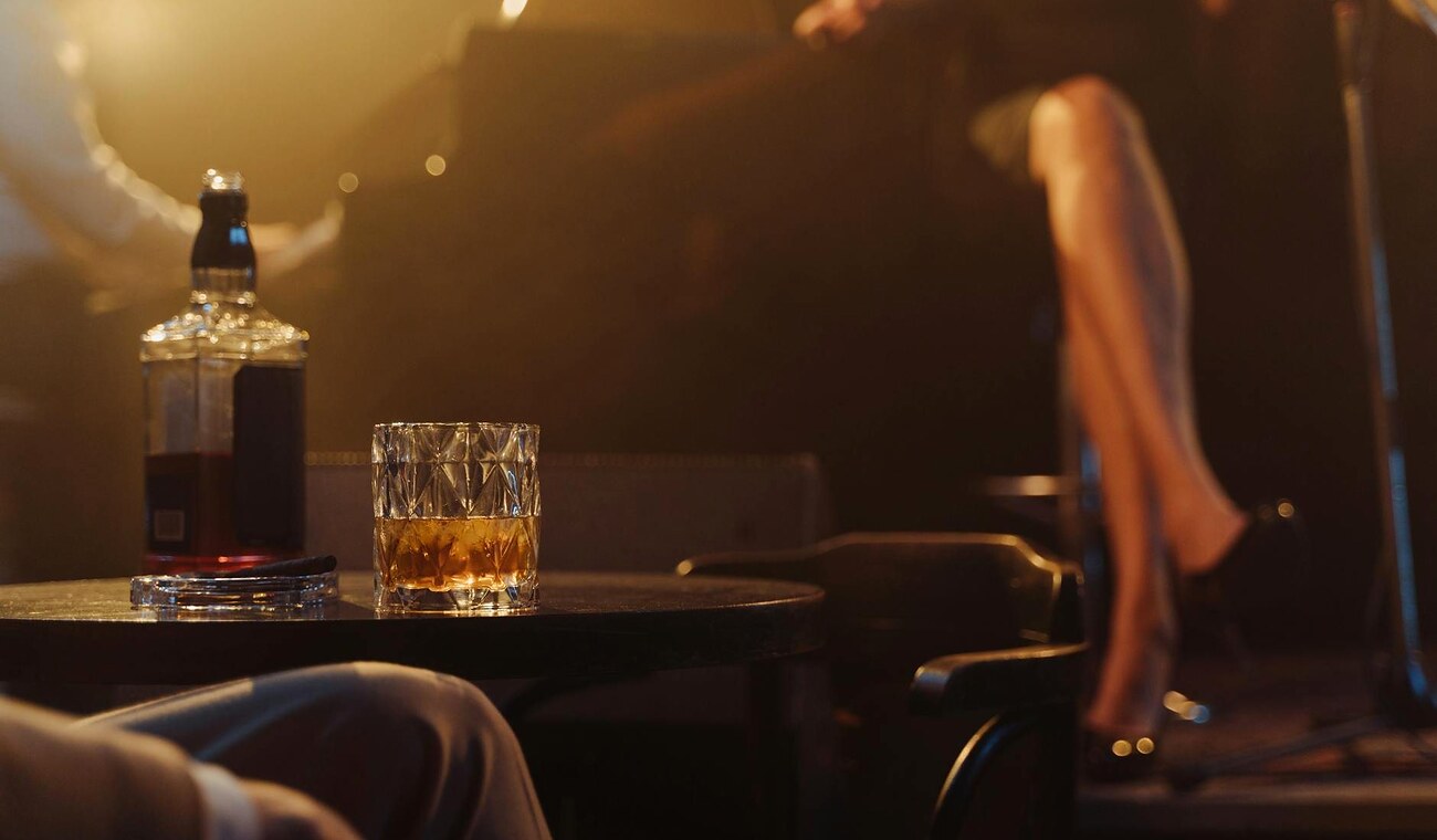 Nastrojowy stolik lounge z drinkiem i ciepłym scenicznym światłem